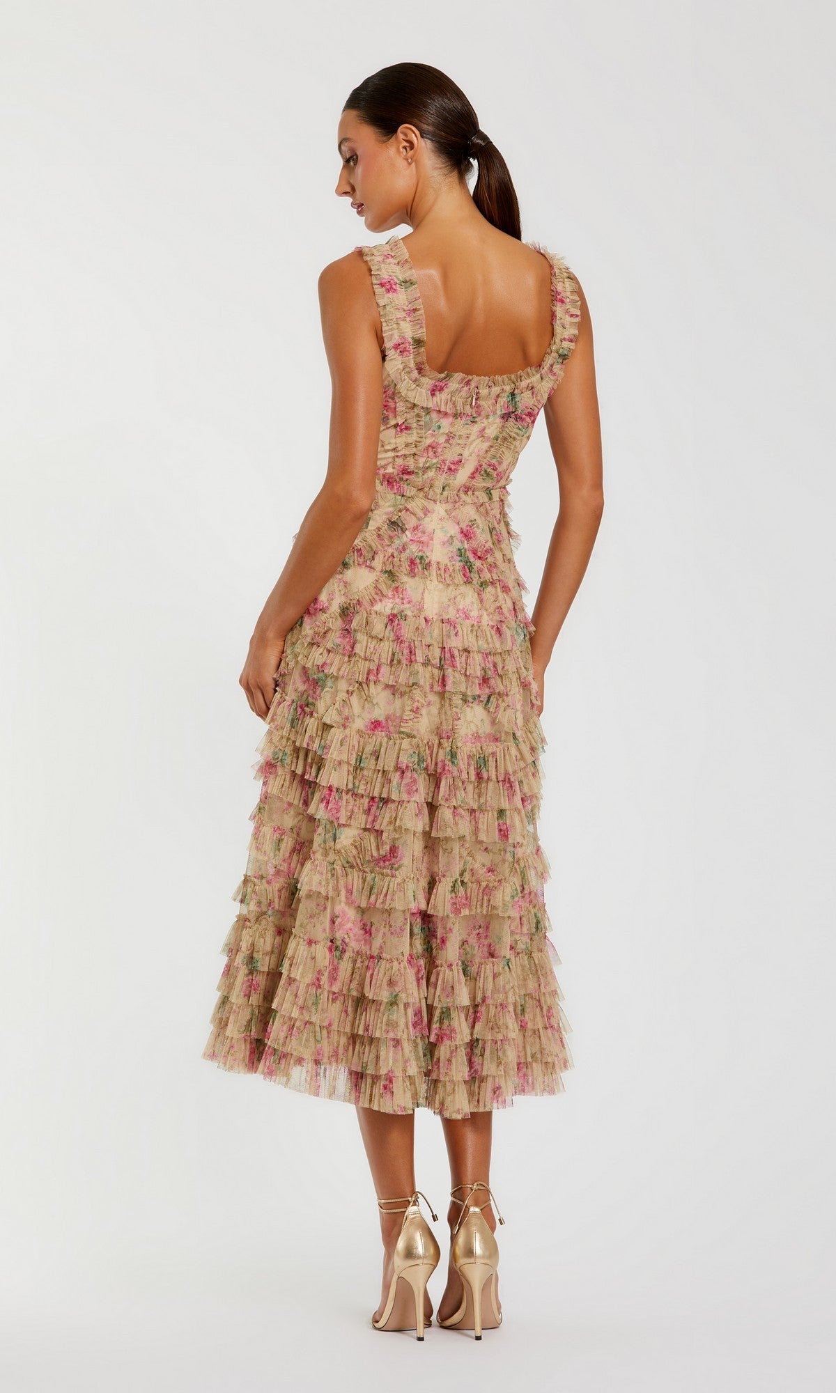 A woman stands facing away against a plain background, wearing the Mac Duggal 8293 midi party dress paired with metallic heels.